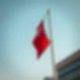 Flag flying upside down on a pole against a clear sky symbolizing distress or signal